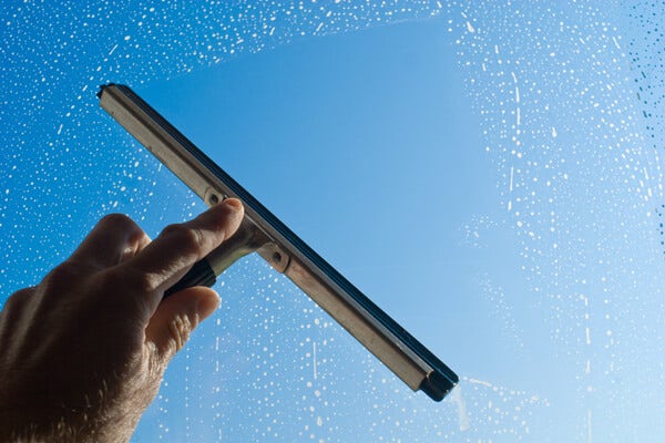 squeegee being used to clean window
